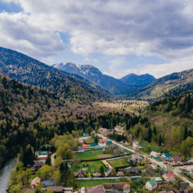Панорама горного посёлка со снежными вершинами вдали