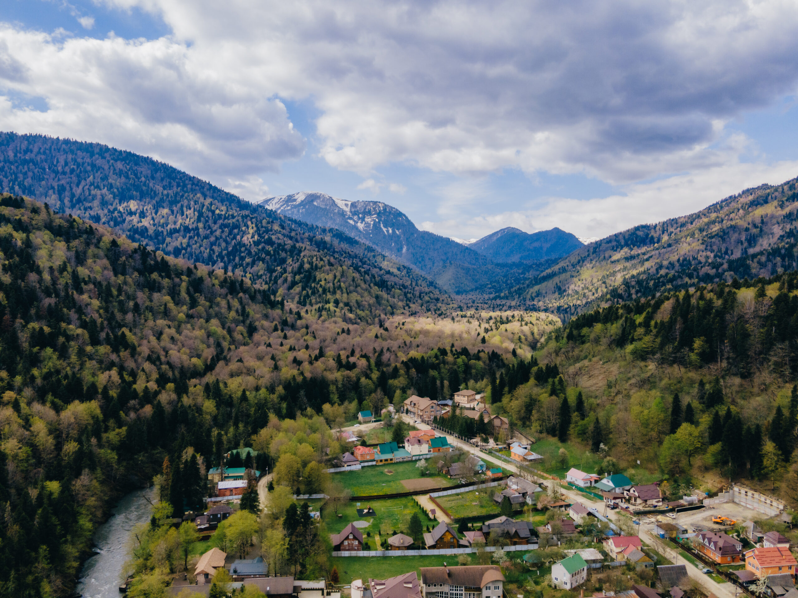Панорама горного посёлка со снежными вершинами вдали
